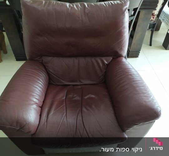 כורסה מעור חום כהה על רצפת אריחים בהירה